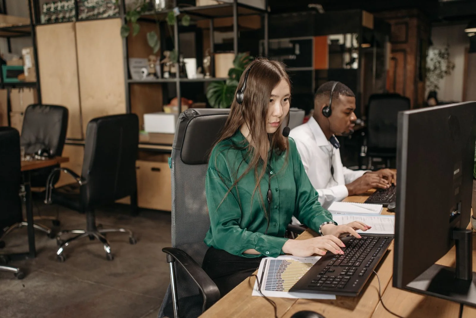 Colleagues working at connected desktop computers.