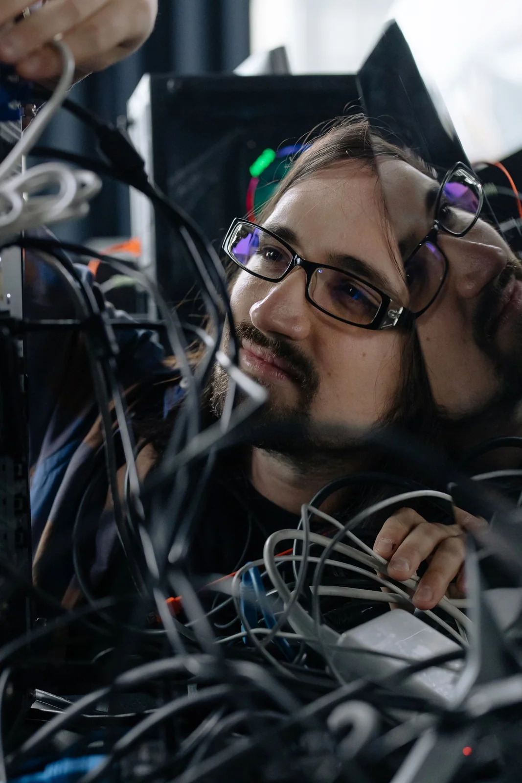 A technician checking network cables and equipment.